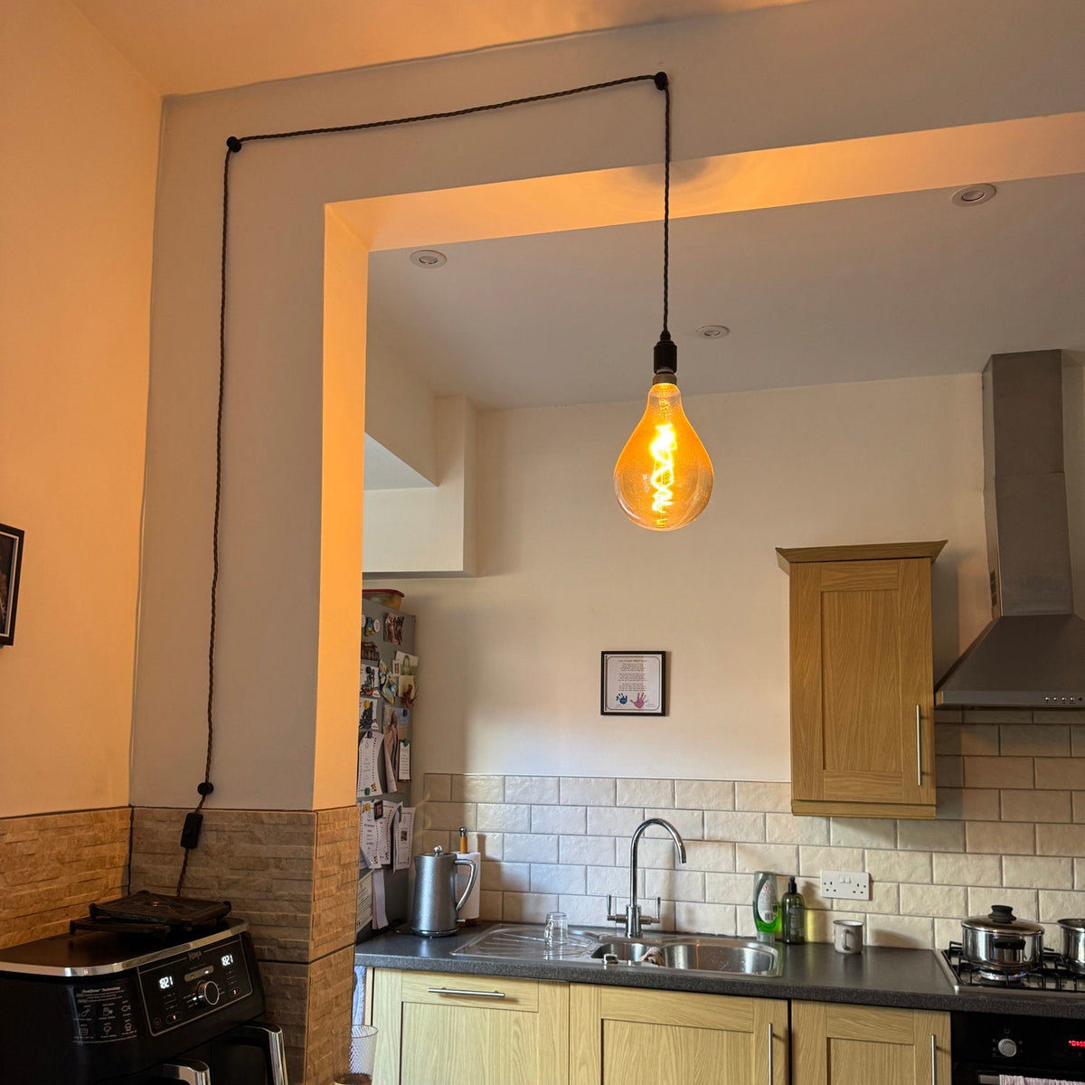 a versatile plug in pendant hangs over a kitchen island